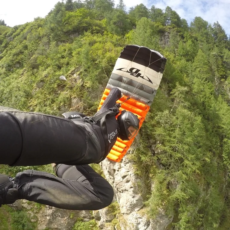 A canopy pilot flying a high-performance parachute through an alpine gorge. Photo: Brianne Thompson, AXIS Flight School