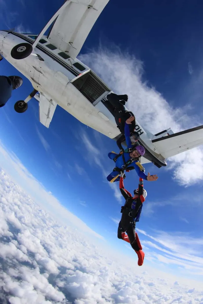 Skydivers exit a Cessna high above the drop zone