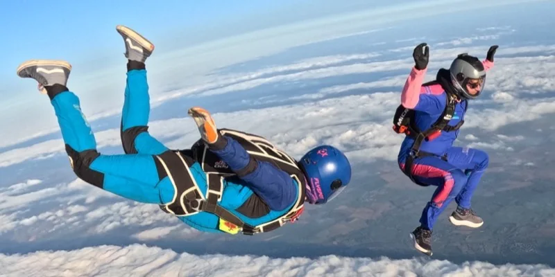 A coach flying beside a jumper above cloud